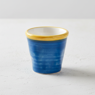 Bicchierino blu su tavolo cemento